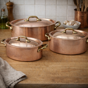 Complete set of three copper casserole dishes ready for cooking