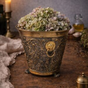 small French vintage cachepot with lion heads and decorative feet.