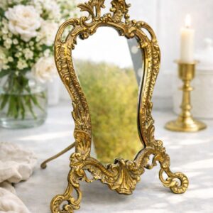 Vintage brass tabletop mirror with ornate French Rococo frame and decorative stand