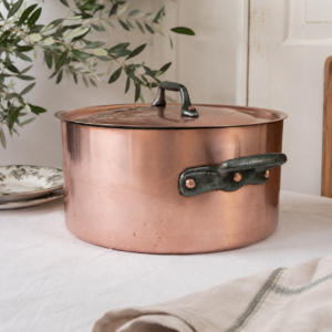 Vintage copper stock pot with lid in French style featuring warm aged patina and traditional tin lining