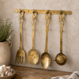 Vintage brass kitchen utensil set with hanging rack featuring large decorative French wall utensils